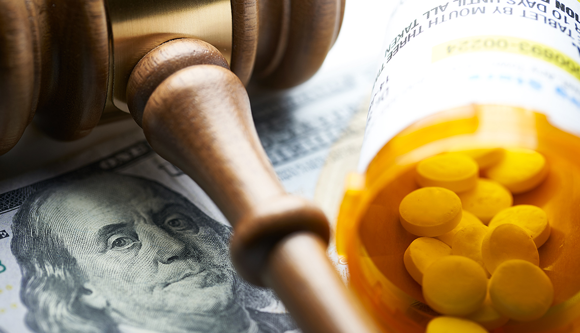 A gavel on top of money and a pill bottle