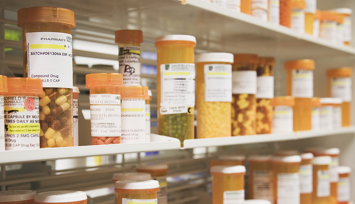 rows of prescription pill bottles on a pharmacy shelf
