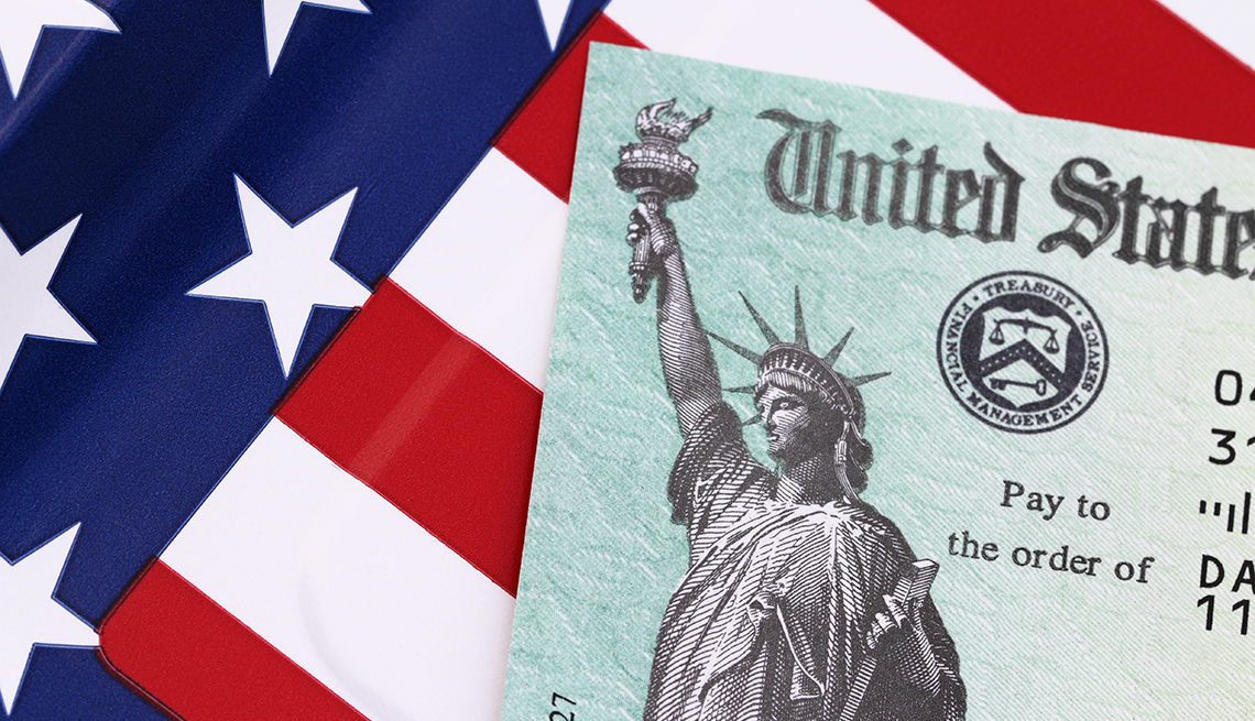 IRS tax refund check on a flag background. Check is showing the Treasury Seal and the Statue of Liberty