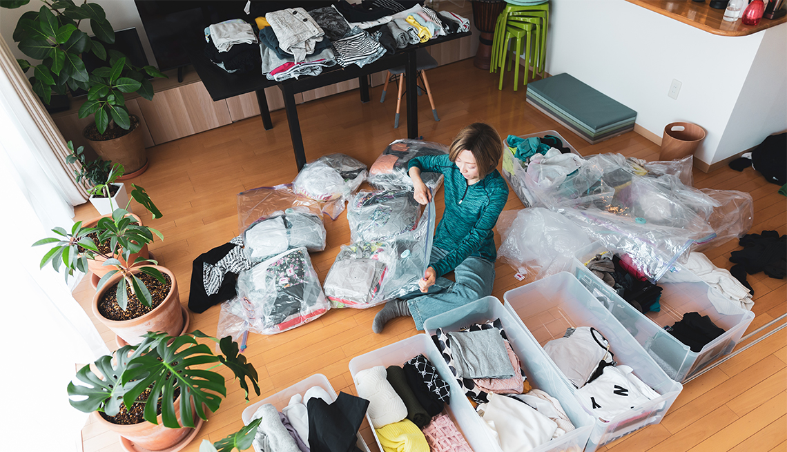 a woman organizes clothes in living room 